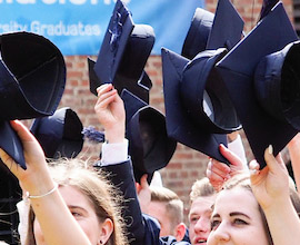 Image of students getting ready to toss their graduation caps